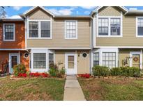 Tan and orange townhouses with landscaping and walkways at 11729 Whitewing Ct, Orlando, FL 32837