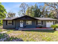 Charming one-story home with stone accents, complemented by a well-manicured lawn and fresh landscaping at 1312 Surf Ave, Apopka, FL 32703