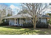 Ranch style home with grey siding, white trim, and rocking chairs on the porch at 1821 Stanley St, Longwood, FL 32750