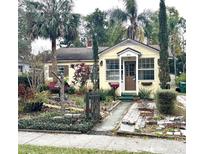 Cute yellow house with landscaped front yard, walkway, and palm trees at 206 Tangerine Pl, Maitland, FL 32751