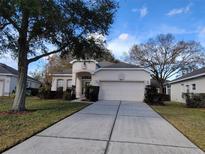 Single-story house with two-car garage and landscaped lawn at 2310 Grasmere Cir, Clermont, FL 34711