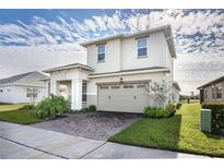 Two-story house with two-car garage, paver driveway, and landscaping at 2709 Greenlands St, St Cloud, FL 34772