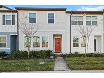 Two-story townhome with red door, neutral siding, and landscaping at 3092 Water Sprite St, Orlando, FL 32808