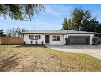 Newly renovated home with a modern farmhouse exterior, featuring a gray garage door and white brick at 3118 Clemwood St, Orlando, FL 32803