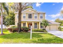 Charming two-story home features a manicured lawn, lush landscaping, and welcoming front porch at 3442 Starbird Dr, Ocoee, FL 34761