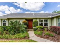 Charming home featuring a well-manicured lawn and a vibrant front door with verdant landscaping at 4818 Breezy Palms Ct, Windermere, FL 34786