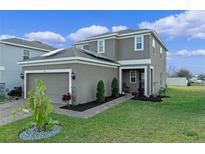 Beautiful two-story home featuring a manicured lawn, brick pathway, and an attached two-car garage at 958 Anna Pl, Davenport, FL 33837