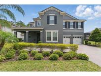 Charming two-story gray home with well-maintained landscaping and a two car garage at 10219 Atwater Bay Dr, Winter Garden, FL 34787