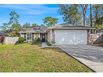 House exterior featuring a neutral color scheme and a two-car garage at 114 W 5Th St, Chuluota, FL 32766