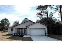 Newly constructed home with white exterior, black accents, and a two-car garage at 702 Marion Oaks Manor, Ocala, FL 34473