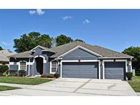Charming single-story home with a gray exterior, well-maintained landscaping, and a three-car garage at 890 Moonluster Dr, Casselberry, FL 32707