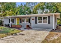 Gray house with yellow door, landscaping, and a long driveway at 1098 S Oleander St, Longwood, FL 32750