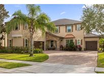 Two-story house with stone accents, landscaped yard, and a three-car garage at 1208 Bella Vista Cir, Longwood, FL 32779