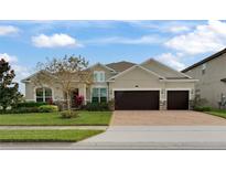 Two-story house with a three-car garage and landscaped front yard at 16672 Broadwater Ave, Winter Garden, FL 34787