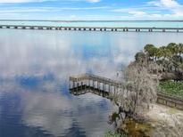 Aerial view of waterfront property with private dock and bridge in background at 2072 Jessup Rd, Oviedo, FL 32765