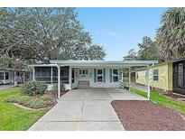 Single-story home with carport and landscaped yard at 228 Westwood Dr, Leesburg, FL 34748