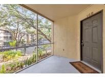 View of patio with gray flooring, screen, and partial view of the parking lot at 629 Dory Ln # 108, Altamonte Springs, FL 32714