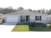 Gray house with a two-car garage and landscaped lawn at 741 Rioja Dr, Minneola, FL 34715