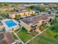 Aerial view of an apartment building with a pool and surrounding landscape at 1000 Lake Of The Woods Blvd # 203E, Casselberry, FL 32730