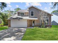 Two-story house with a large front yard and attached garage at 11172 Cypress Leaf Drive, Orlando, FL 32825