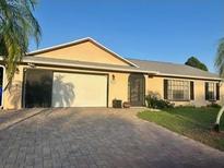 Charming single-story home featuring a brick-paved driveway and well-maintained landscaping at 2537 Lanier Rd, Kissimmee, FL 34744