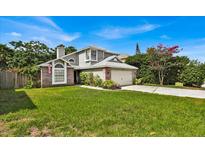 Two-story house with gray siding, brick accents, and a well-maintained lawn at 377 River Chase Dr, Orlando, FL 32807