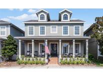 Two-story house with gray siding, a large front porch, and landscaping at 420 Park Lake Dr, Winter Springs, FL 32708