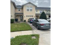 Two-story townhome with attached garage and driveway parking at 5454 Caramella Dr, Orlando, FL 32829
