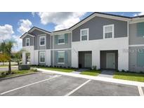 Two-story townhome with gray siding and teal accents at 7530 Oak Spring Ln, Davenport, FL 33837