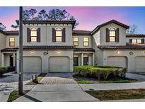 Two-story townhome with attached garage and landscaped front yard at 8177 Roseville Blvd, Davenport, FL 33896