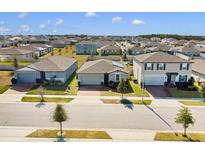Aerial view of three houses in a new suburban neighborhood at 841 Teton St, Haines City, FL 33844