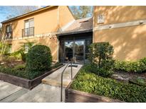 Condo building exterior showcasing landscaping and entrance at 90 Moree Loop # 15, Winter Springs, FL 32708