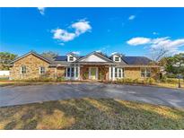 Brick home with solar panels, a large driveway, and well-manicured landscaping at 1203 Waverly Way, Longwood, FL 32750