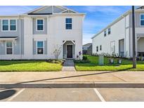 Two-story house with gray siding, landscaping, and a paved walkway at 1274 Shoreside St, Clermont, FL 34714