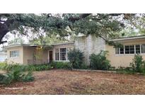 Ranch-style home with mature landscaping and brick facade at 1425 N Hiawassee Rd, Orlando, FL 32818