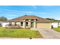 Charming single-story home featuring a well-maintained lawn and attached two-car garage at 1834 Roper Rd, St Cloud, FL 34771