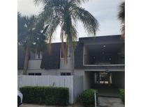 Condo building exterior with palm trees and white fence at 1928 Conway Rd # 23, Orlando, FL 32812