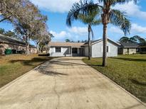 Newly painted home with a long driveway and palm trees at 270 Debary Dr, Debary, FL 32713