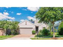 Two-story house with neutral siding, stone accents, and a landscaped yard at 305 Silver Maple Rd, Groveland, FL 34736