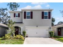 Two-story house with gray siding, brown shutters, and a two-car garage at 325 Pelham Park Dr, Deland, FL 32720