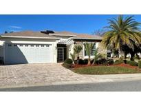 Single-story home with stone accents and a white garage door at 5114 Jareds Landing Way, Oxford, FL 34484