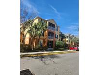 Three-story apartment building with yellow walls and palm trees at 6240 Contessa Dr # 101, Orlando, FL 32829