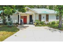 White house with red door, teal roof, and rocking chairs on porch at 750 S Dudley Ave, Bartow, FL 33830