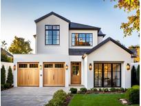 Two-story modern home with light-colored facade, wood garage doors, and landscaping at 785 N Phelps Ave, Winter Park, FL 32789