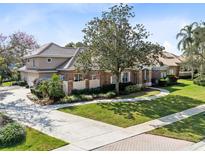 Stunning brick home with a tile roof, lush landscaping, and a beautiful circular driveway at 103 Arrowhead Ct, Winter Springs, FL 32708