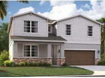 Two-story home with shingle siding, stone accents, and a two-car garage at 1200 White Ash Loop, Deland, FL 32720