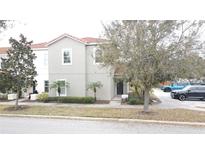 Charming two-story home with a well-manicured lawn, neat shrubbery, and mature trees lining the driveway at 1230 Las Fuentes Dr, Kissimmee, FL 34746