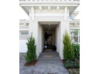 Inviting front entrance with a covered walkway, stone pathway, and lush landscaping at 13586 Abberwick Dr, Orlando, FL 32832