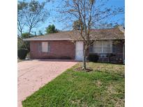 Charming single-story home with brick facade, mature tree, and well-maintained lawn at 1420 Thousand Roses S Dr, Lake Wales, FL 33853