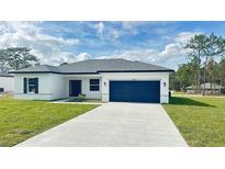 Charming single-story home featuring a blue garage door, and well-manicured lawn at 15122 Sw 61St Court Rd, Ocala, FL 34473